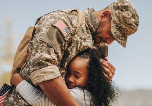 Emotional soldier saying his goodbye to his daughter before going to war. Patriotic serviceman embracing his child before leaving to go serve his country in the military.